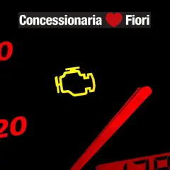 Cruscotto con spia motore accesa. "Concessionaria Fiori" in alto.