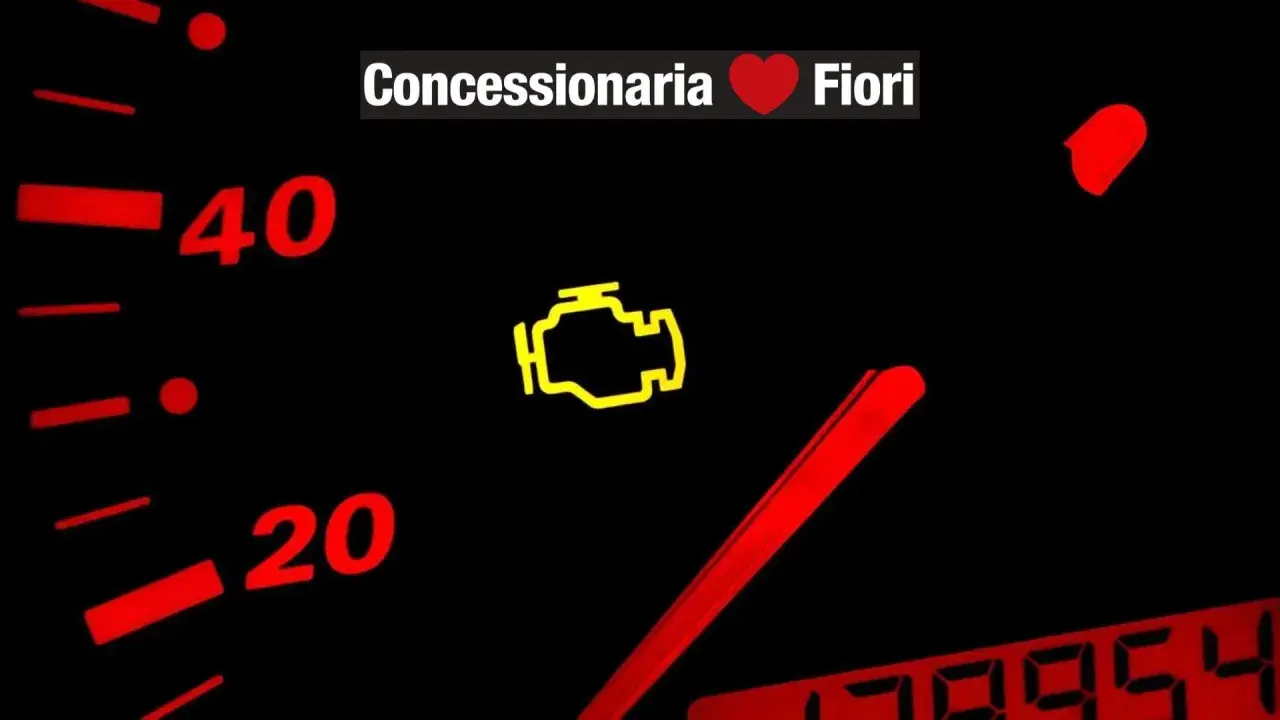 Cruscotto con spia motore accesa. "Concessionaria Fiori" in alto.