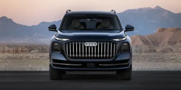 L'imponente Audi Q9 si staglia su uno sfondo desertico, con la sua griglia audace e i fari affilati che catturano lo sguardo.
